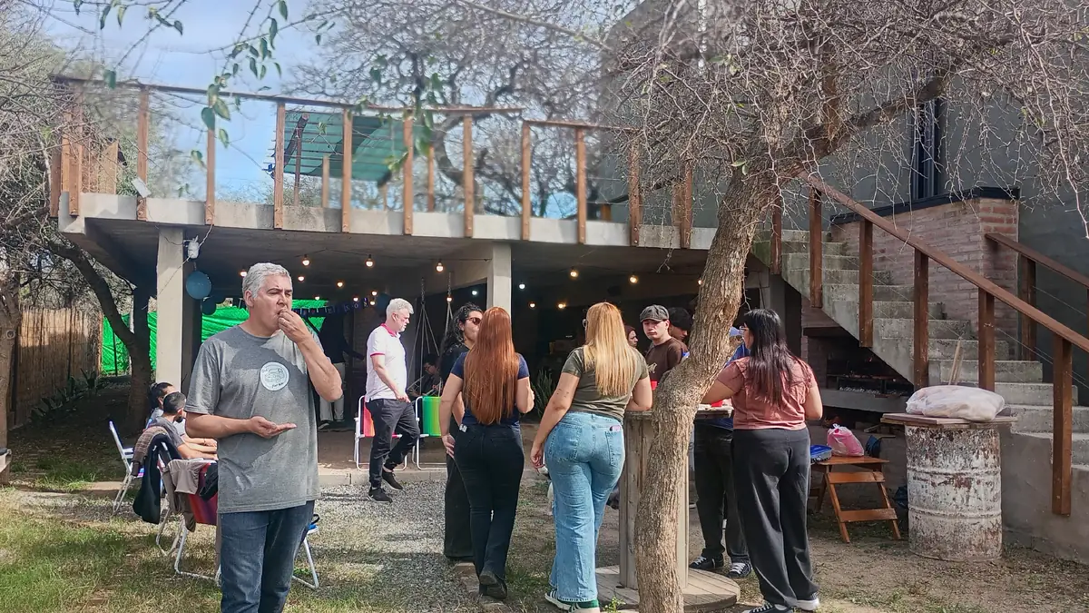 Grupo reunido en el jardín del Club, bajo la sombra del árbol central, durante un encuentro social
